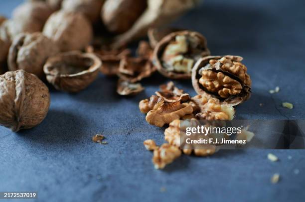group of nuts on blue wood - nozes imagens e fotografias de stock