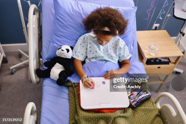 top view of a girl lying in the hospital while coloring something - hospital bed drawing stock pictures, royalty-free photos & images