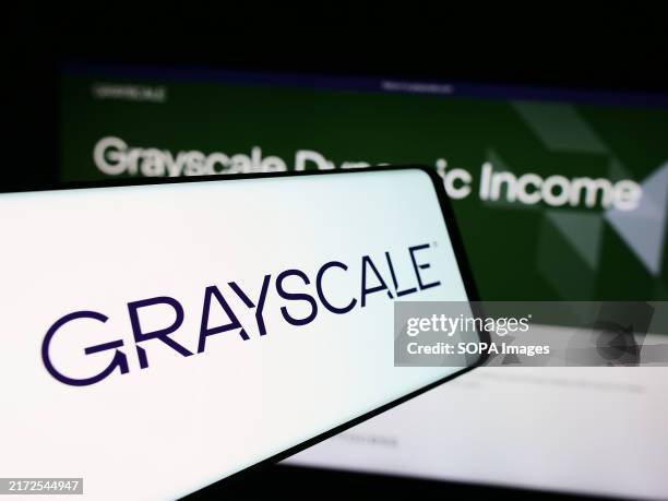 In this photo illustration, the American crypto management company Grayscale Investments LLC logo seen displayed on a smartphone in front of website.
