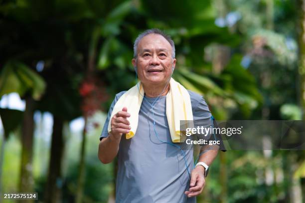 senior man jogging in the park - southeast asian people stock pictures, royalty-free photos & images