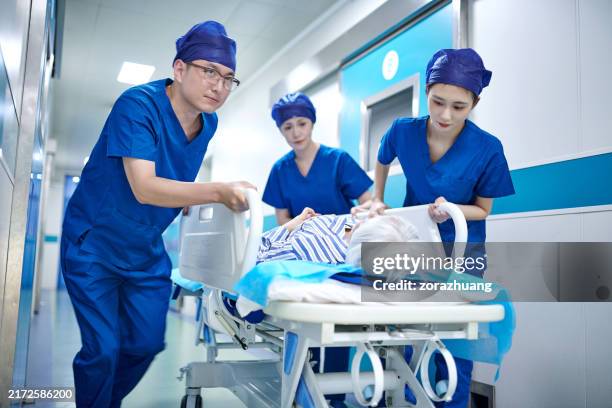 medical first aid team pushing emergency stretcher bed running in corridor - pushing stretcher stock pictures, royalty-free photos & images
