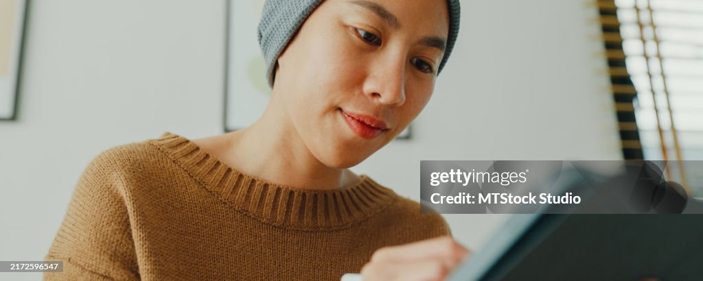 Closeup of young Asian woman sick with cancer in a headscarf use