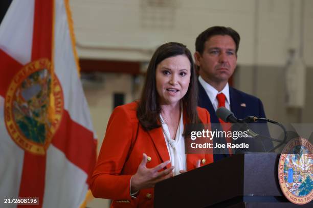 Florida Gov. Ron DeSantis listens as Florida Attorney General Ashley Moody speaks during a press conference regarding an apparent assassination...