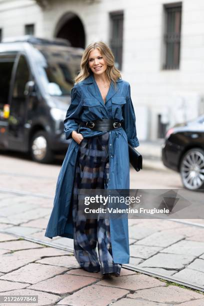 Guest is seen wearing an extra long light blue cargo shirt, blue, light blue and grey printed wide leg trousers, a black leather bag and a black...