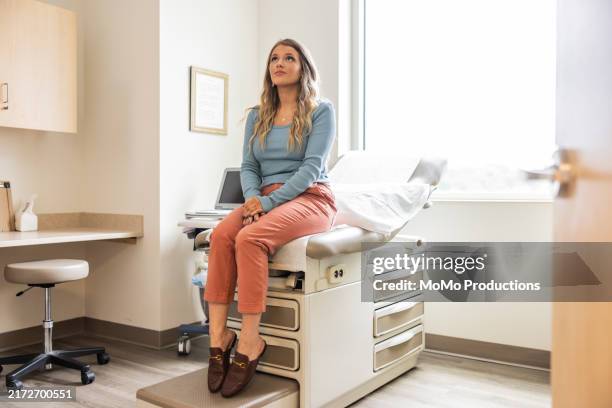 young female patient waiting in doctor's exam room - examination table stock pictures, royalty-free photos & images