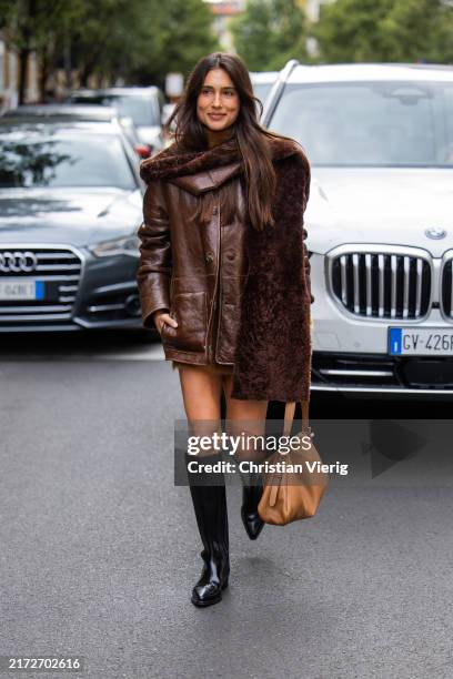 Belen Hostalet wears brown leather jacket, scarf, beige bag, black boots outside Alberta Ferretti during the Milan Fashion Week Menswear...