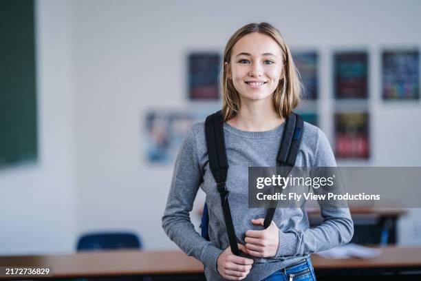 sorridente ragazza della scuola media si trova nella sua classe - educazione secondaria di scuola media foto e immagini stock