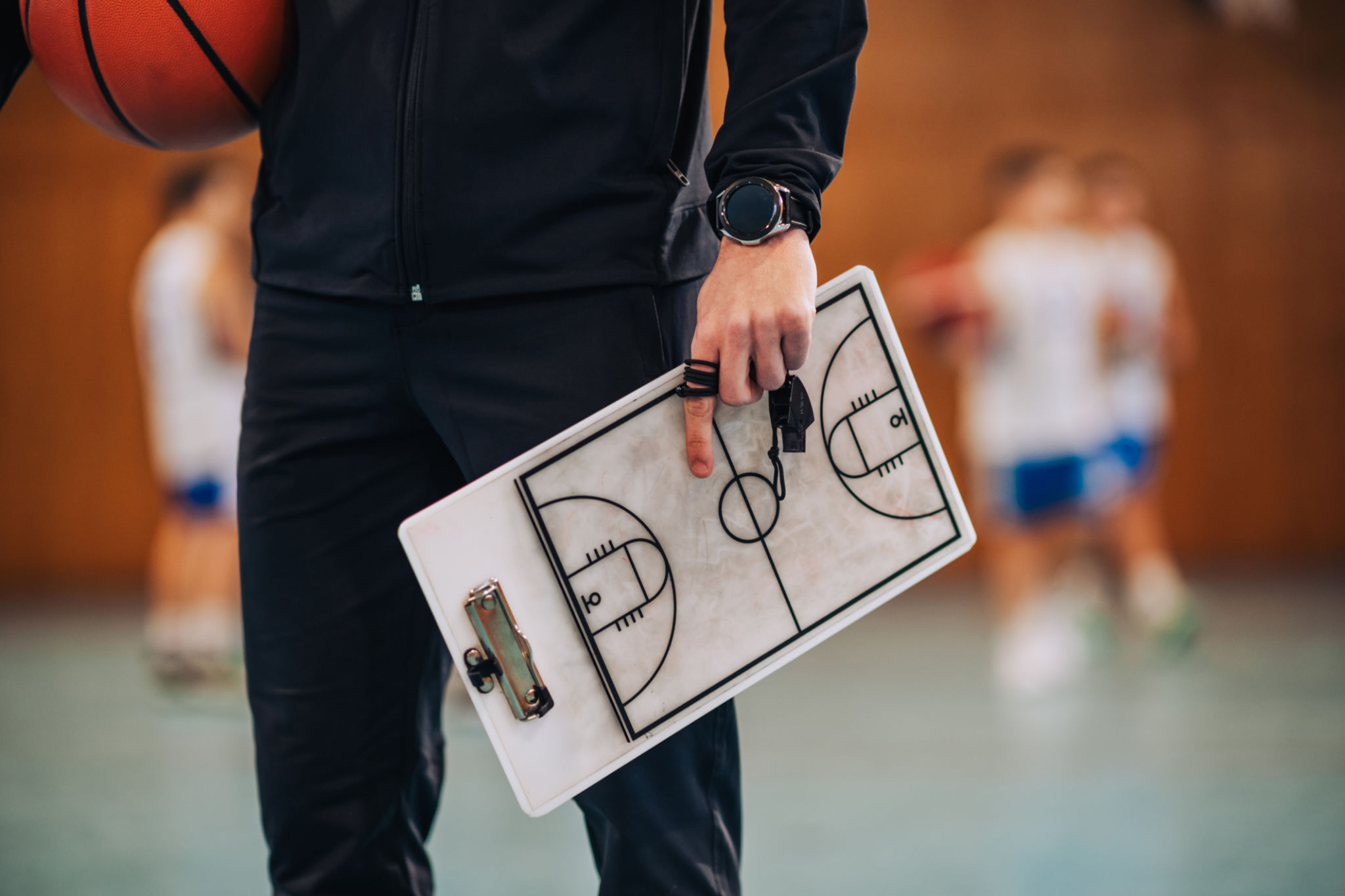 Coach holding basketball playbook Coach holding basketball playbook