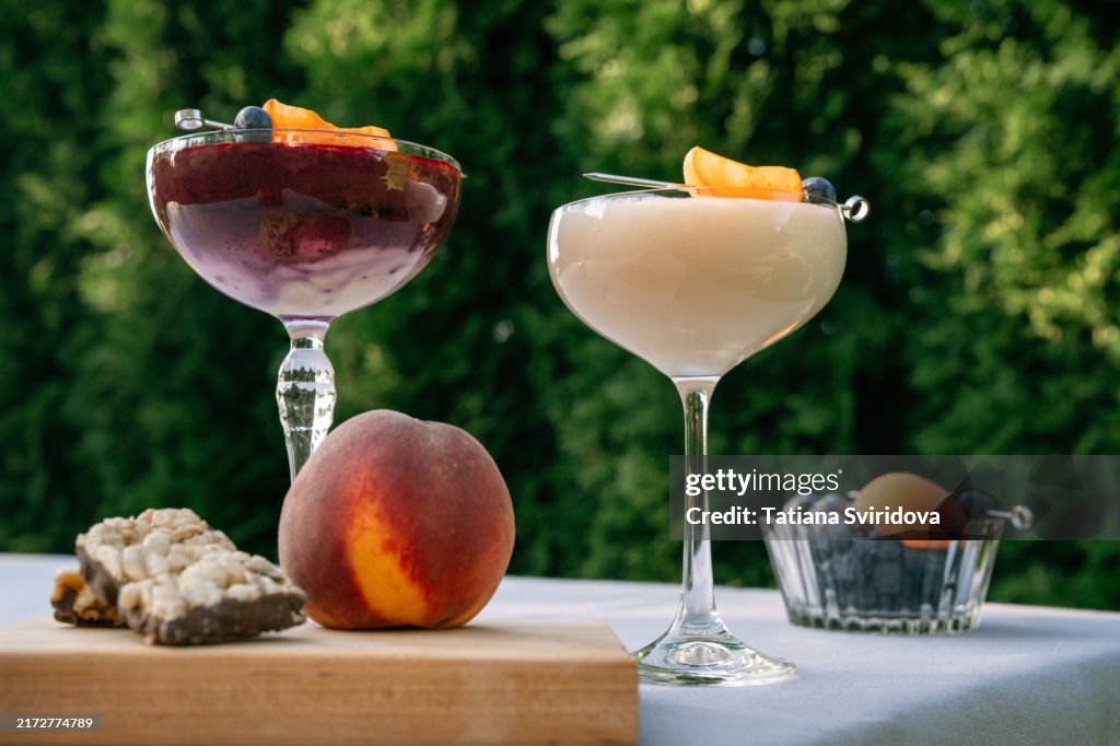 Cocktail glasses with fruit smoothie mocktail on a garden table