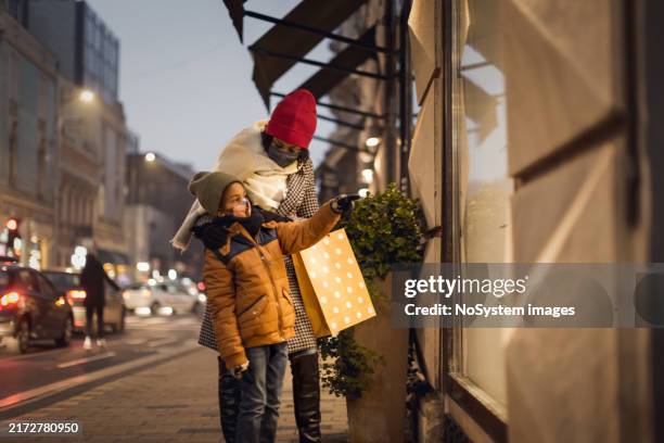 family shopping evening in city center - mom son facial stock pictures, royalty-free photos & images