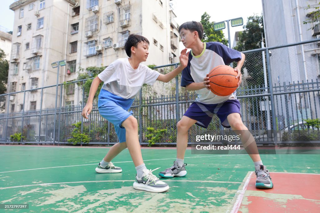 Two boys playing basketball