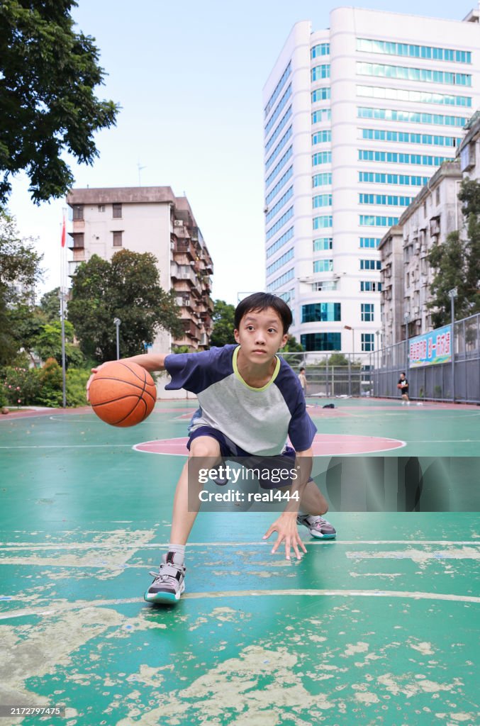 Cute Asian boy playing basketball