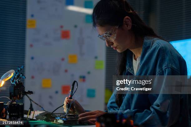 robot engineer working with the circuit board, assemblies, and soldering for control simulated robotics hand in the assembly room. - lead testing stock pictures, royalty-free photos & images