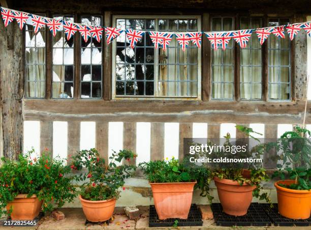 british flag bunting outside historic tudor house in rye, uk - imóvel tombado imagens e fotografias de stock
