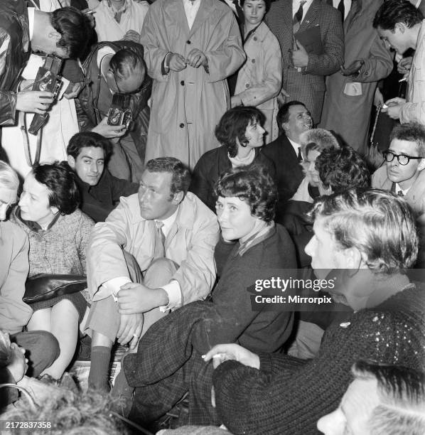 The angry young man playwright, John Osborne, sits it out with demonstrators, centre, next to him is writer Doris Lessing. 17th September 1961. Ban...