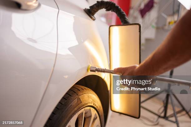repairing car dent after the accident by paintless dent repair - verbeult stock-fotos und bilder