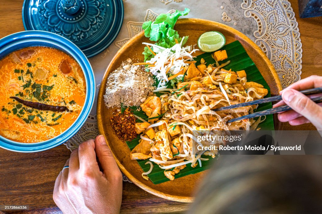 Woman tasting the traditional noodles and curry soup