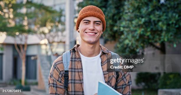 university, student and man in portrait outdoor on campus with book for education, learning and scholarship. gen z, person and happy at college for studying, knowledge or backpack for research - scholarship search stock pictures, royalty-free photos & images