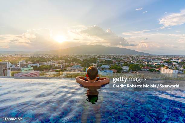 happy boy admiring sunset from an infinity pool - cidade de chiang mai imagens e fotografias de stock
