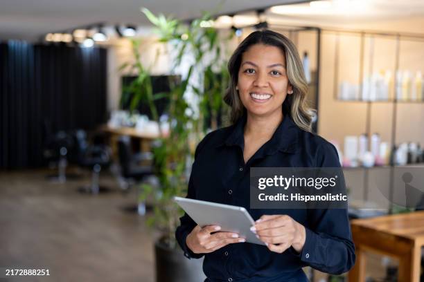 hairdresser working at a hair salon using a digital tablet - beauty spa stock pictures, royalty-free photos & images