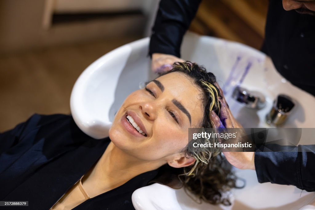 Woman at a hair salon dyeing her hair and getting a massage