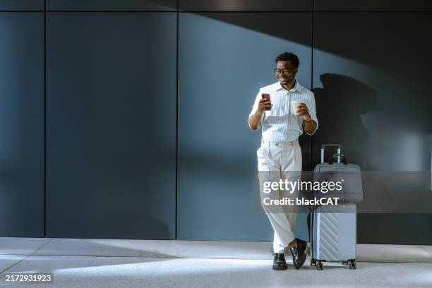 business traveler with smartphone and coffee at airport - business travel stock pictures, royalty-free photos & images