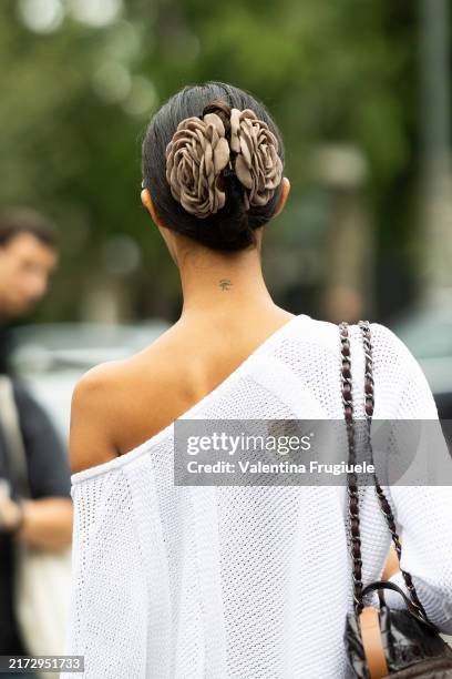 Guest is seen wearing 3d fabrics headpieces, a brown leather bag and a white one-shoulder knitted sweater outside Boss show during the Milan Fashion...