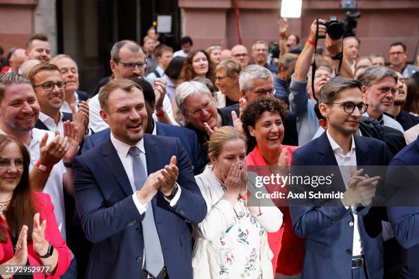 Party members and supporters react to initial election results that give the party a narrow first place finish in Brandenburg state elections on...