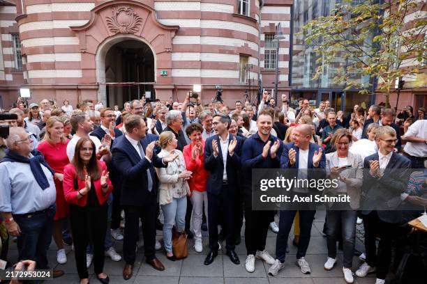 Party members and supporters react to initial election results that give the party a narrow first place finish in Brandenburg state elections on...