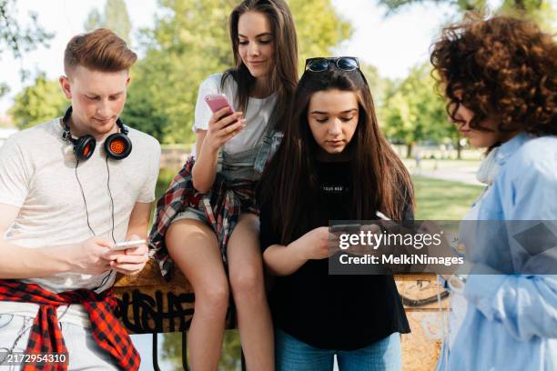 group of teenager looking at their mobile phone on social networks - millennial generation stock pictures, royalty-free photos & images