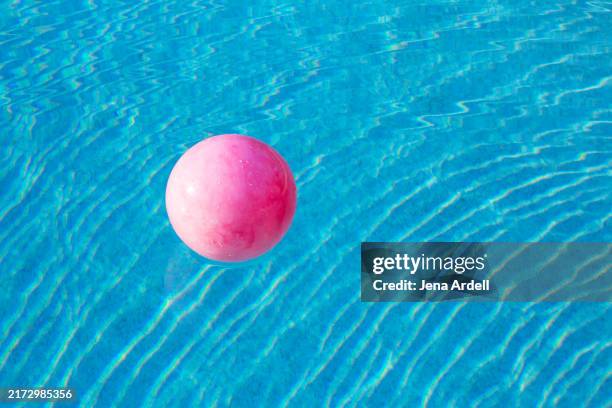 swimming pool background with pink ball floating on water ripples - plastic swimming pool stock pictures, royalty-free photos & images