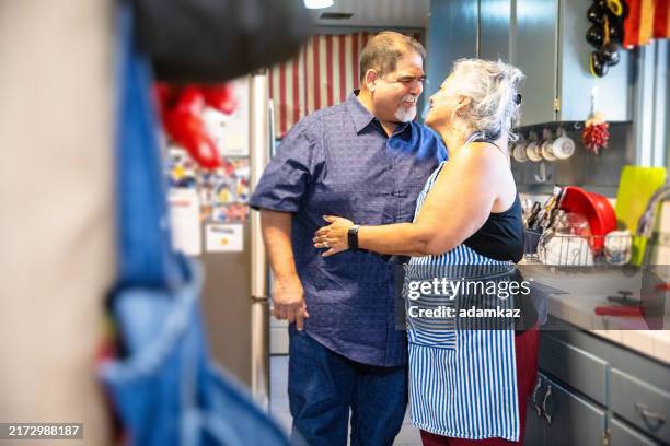 hispanic woman making dinner in kitchen with her husband - large dinner party stock pictures, royalty-free photos & images