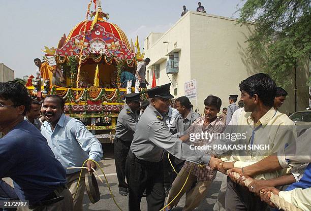 Indian men pull a chariot during the Jagannath Rath Yatra festival in New Delhi, 01 July 2003. During the festival, images of Jagannath, his brother...