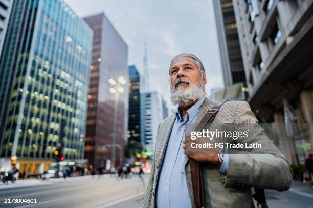 homem de negócios sênior que contempla na cidade - trabalho na terceira idade - fotografias e filmes do acervo