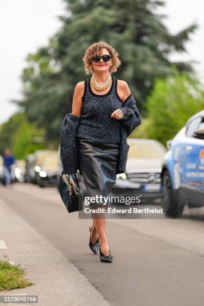 Renia Jaz wears black sunglasses, silver chrome beaded necklace, gold beaded necklace, dark gray white pattern top, dark gray white pattern oversized...