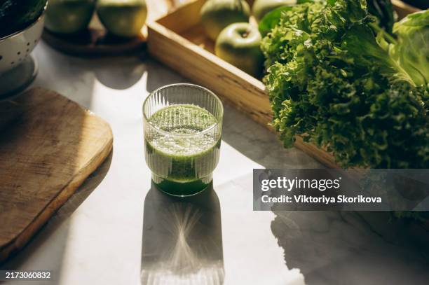 vegetarian healthy green smoothie from avocado, spinach leaves, apple and chia seeds on gray concrete background. selective focus. space for text. - selderij stockfoto's en -beelden