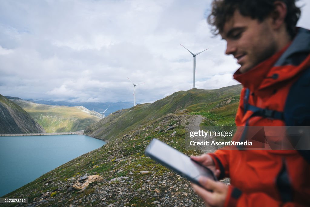 Backpacker uses digital tablet above alpine lake