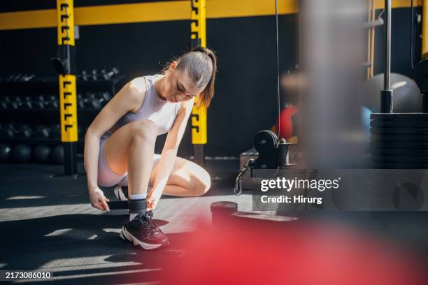 individual setting up ankle weight for gym exercise - ankle weights stock pictures, royalty-free photos & images