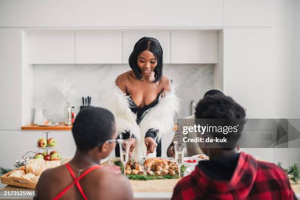 celebrating thanksgiving day. happy african american friends talking during thanksgiving meal at dining table - stuffed turkey stock pictures, royalty-free photos & images