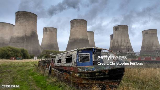 Narrow boats waiting for renovation stand in a marina yard next to the eight giant cooling towers of Ratcliffe On Soar Power Station on September 19,...