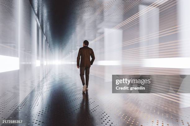 businessman walking in empty futuristic glass and metal corridor - man walking silhouette stock pictures, royalty-free photos & images