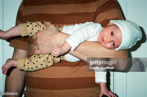 Father Holding His 3 Month Old Baby With One Arm Laying Baby On Her Side High-Res Stock Photo