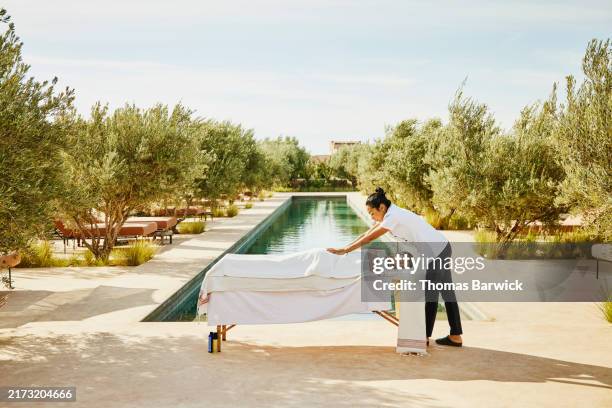 wide shot guest receiving poolside massage at tropical luxury resort - exoticism stock pictures, royalty-free photos & images