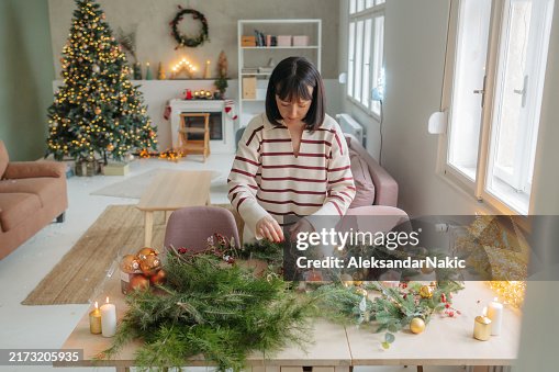 Young woman making a Christmas wreath Young woman making a Christmas wreath