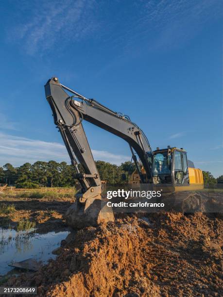 excavator - heavy equipment - new construction home site - north carolina - empty lot - close up low angle vertical - grondverzetmachine stockfoto's en -beelden