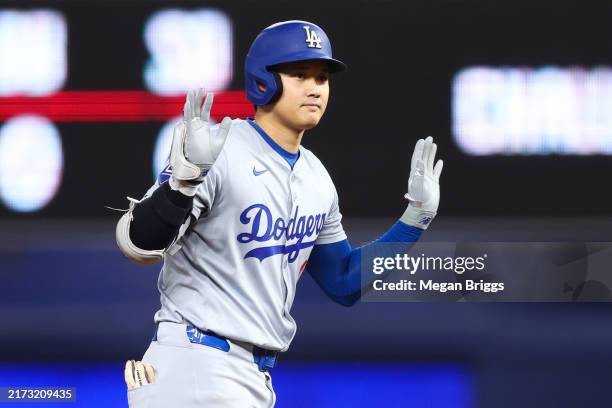 Shohei Ohtani of the Los Angeles Dodgers reacts after hitting a double against the Miami Marlins during the first inning of the game at loanDepot...