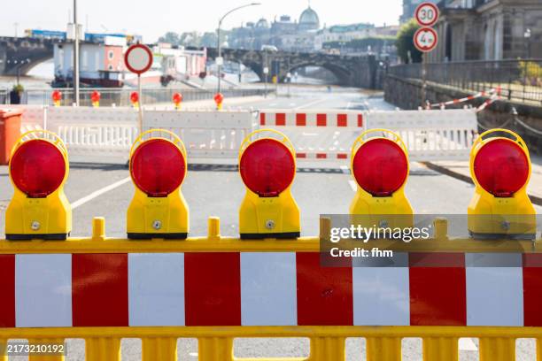 warning lights and a barrier - road closed due high tide in dresden, saxony/ germany - barricade stock pictures, royalty-free photos & images