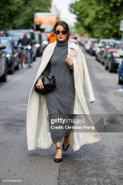 Alexandra Pereira wears grey knitted dress, black bag, creme white coat outside Max Mara during the Milan Fashion Week Menswear Spring/Summer 2025 on...