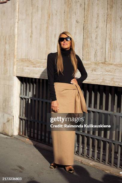 Anna Dello Russo wears a long beige skirt and black long sleeve turtle neck topoutside Max Mara show during the Milan Fashion Week Menswear...