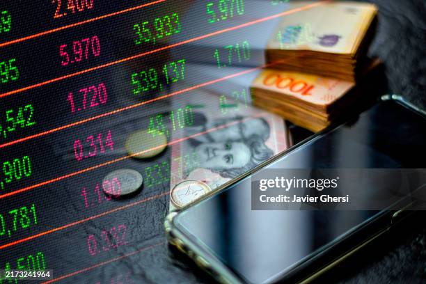 smartphone, argentine pesos in cash, dollars and stock market indicators - economy graph - international monetary fund stock pictures, royalty-free photos & images